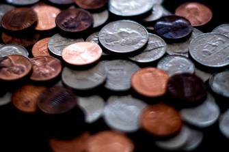 Stacks of US coins, including pennies, quarters, and nickels.