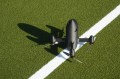 A drone sitting outside on a turf field.