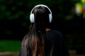 A person wearing over the ear headphones photographed from behind.