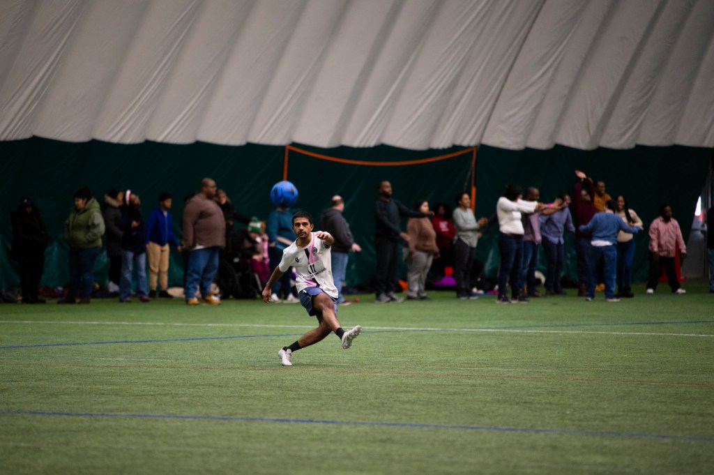 A person kicking a soccer ball inside of the Carter Field Bubble.