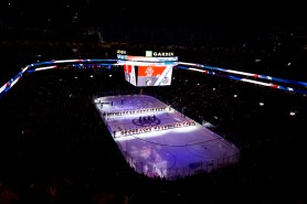 A wide image of the ice and audience inside TD Garden with dramatic purple lighting during the 2025 Beanpot.