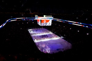 A wide image of the ice and audience inside TD Garden with dramatic purple lighting during the 2025 Beanpot.