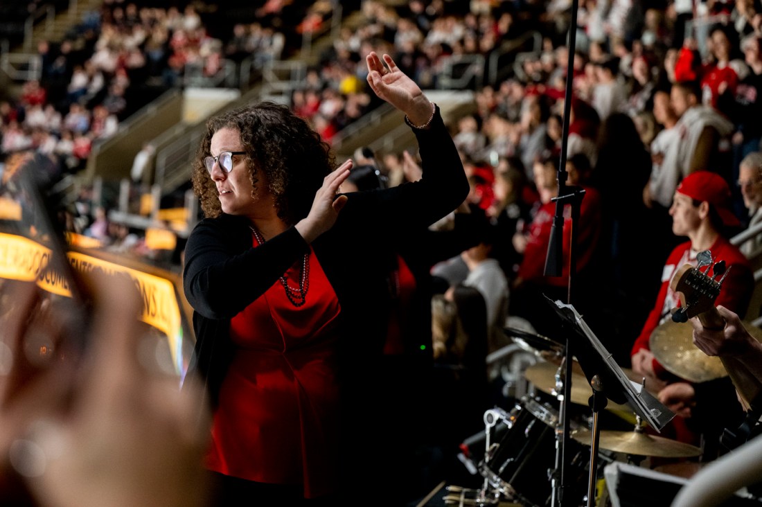 Allison Betsold, leader of Northeastern's pep band, conducting the band during the Beanpot semifinal at TD Garden.