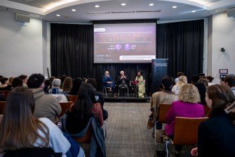 Denise Garcia, Ghaith al-Omari and Dennis Ross sitting on stage at the front of a room full of audience members listening to their fireside chat.