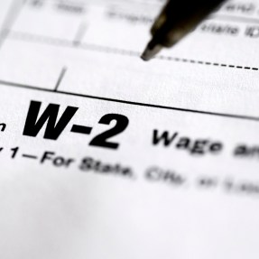 A pen hovering above a tax form that says 'form W-2 copy 1' on it.