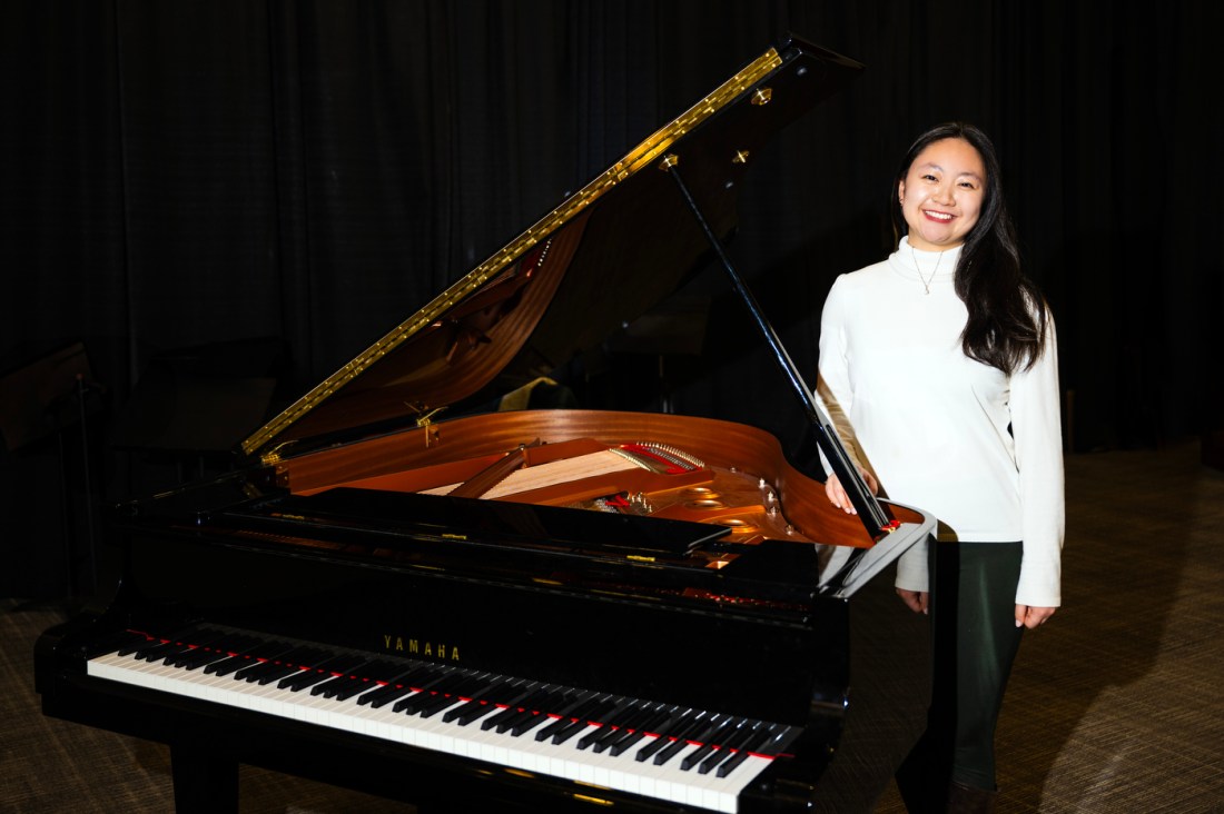 Bonnie Liu standing next to a piano smiling.