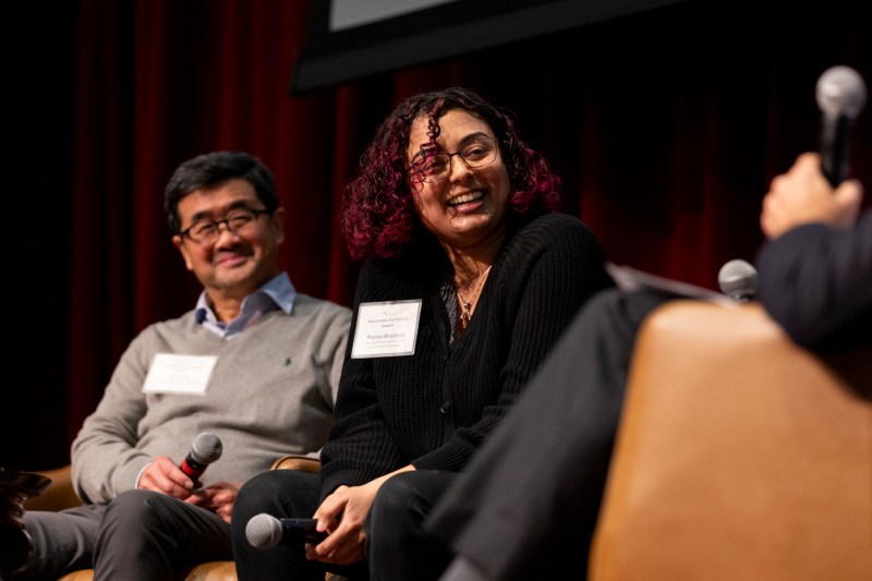 Alan Eng and Rasika Bhalerao smiling while sitting on stage at the Summit.