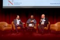 James Genone, Vinay S. Rao, and Usama Fayyad sitting on stage in tan leather chairs. Each of them is holding a microphone.