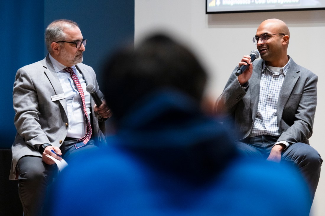 Gregory Abowd sitting next to another person who is speaking into a microphone. 