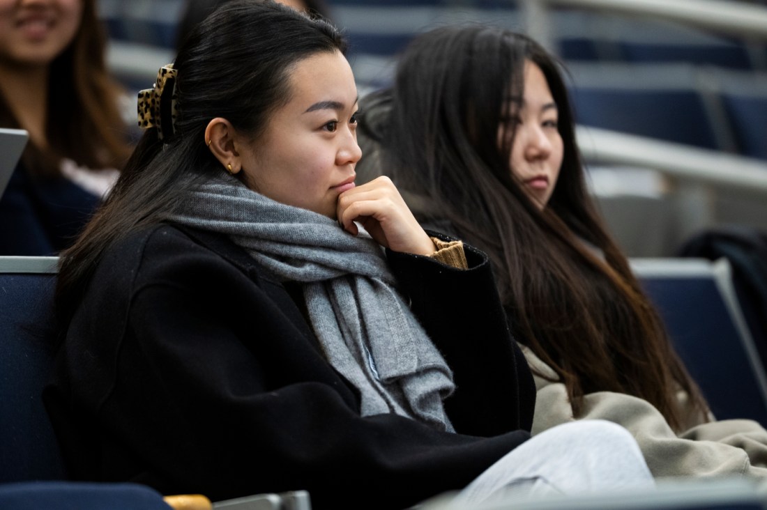 Two audience members listening intently at a panel discussion. 