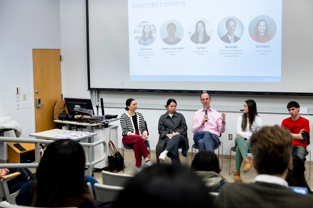 Mike Armini sitting next to Shirley Wang, Joaquin Crosby-Lizarde, Ivy Chen and Bre McClarey at the front of a classroom. 