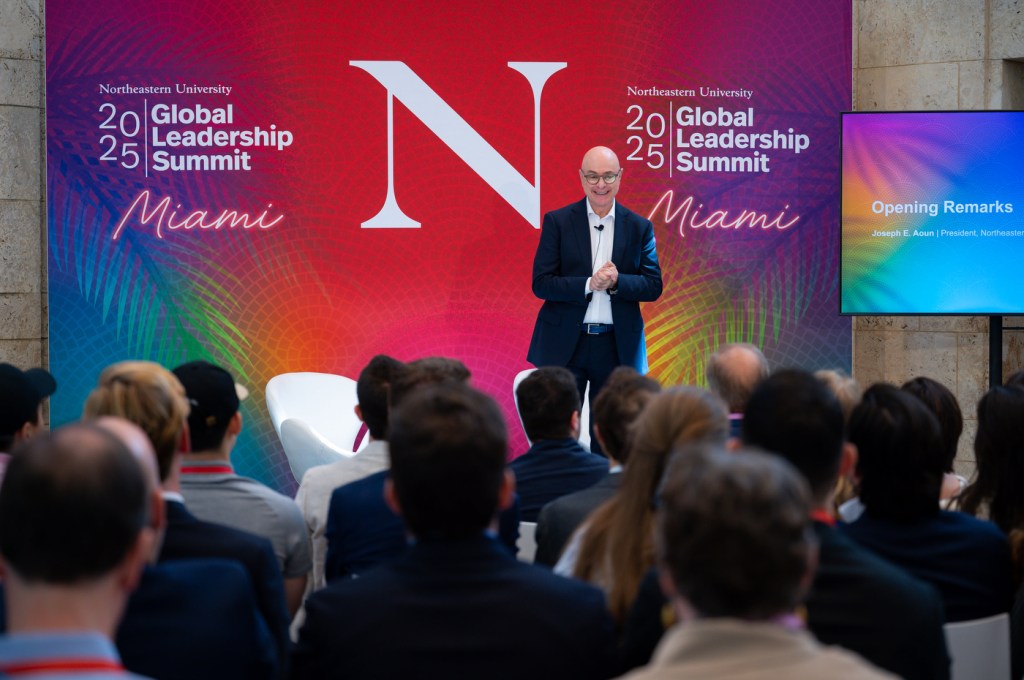 Northeastern President Aoun standing on stage at the front of a room at the Global Leadership Summit in Miami.