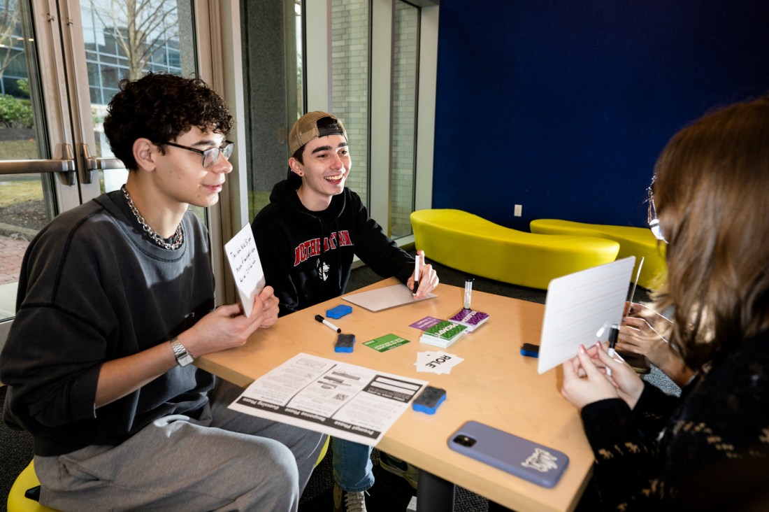 Several people sitting in a room working on a game. 