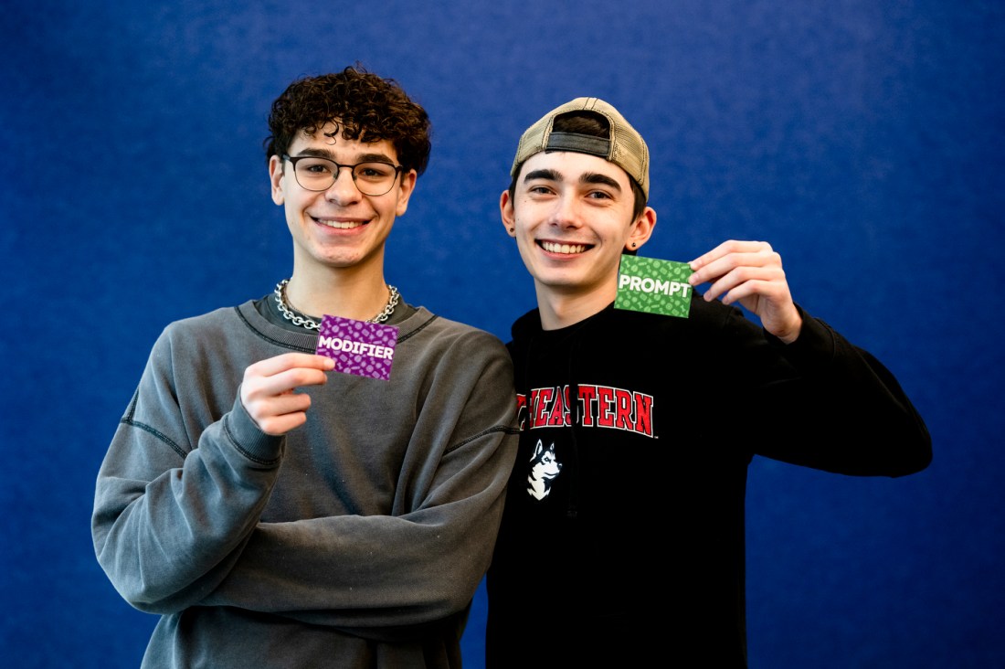 William Wennik and Jacob Ohlson posing with cards that say 'Modifier' and 'Prompt' on them.