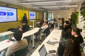 Asif Hussain standing in front of a room full of students.