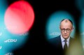 Friedrich Merz wearing a suit and tie speaking at a press conference.