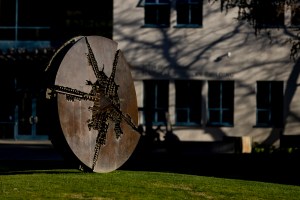 A disc shaped sculpture on a grassy lawn in Oakland.