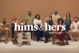 A still from the Hims & Hers Super Bowl ad that shows a room full of diverse people, some sitting and some standing with 'hims & hers' in white text overlaid.