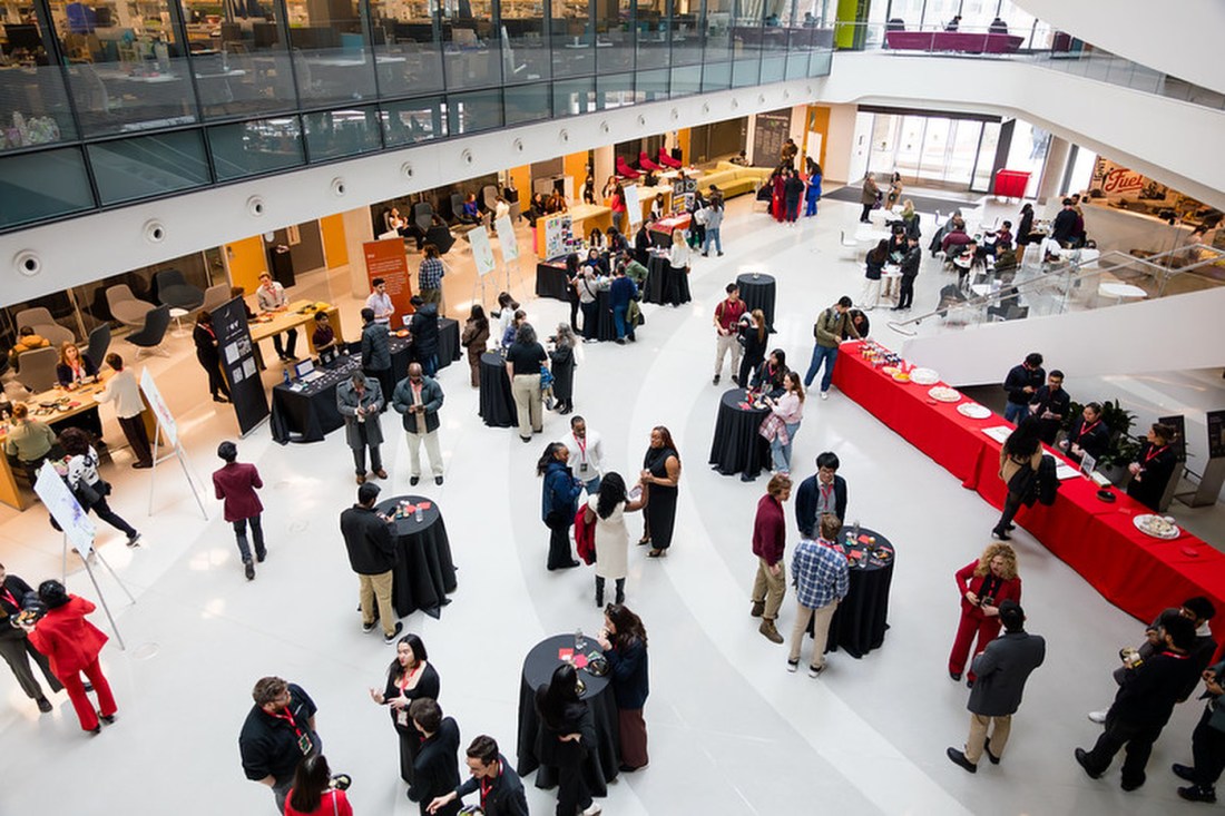 People mingling around the lobby of a building at an event.