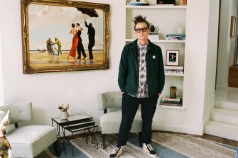 Mark Hoppus standing in a living room in front of a rare Banksy piece.