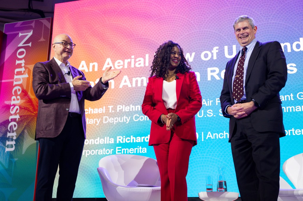 Northeastern President Aoun standing on stage with two other people at the Northeastern Global Leadership Summit.