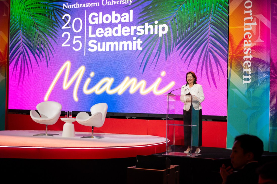 A speaker standing on stage at a clear podium.