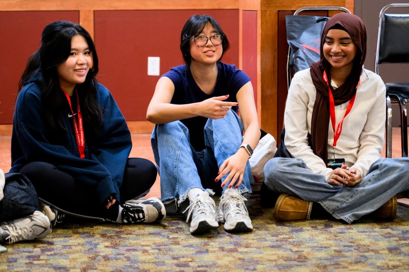 Students engage with each other during an event inside a campus building.