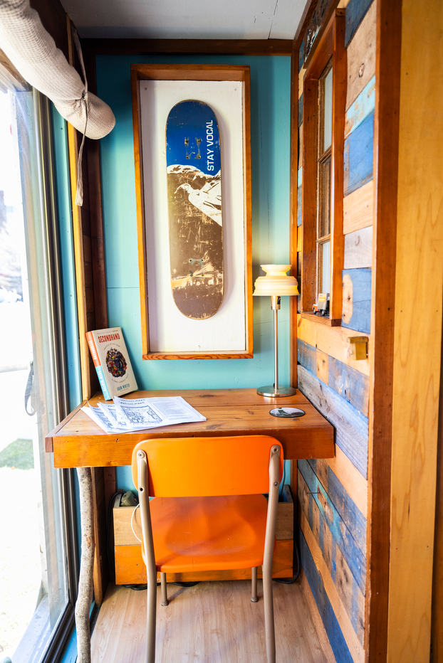 A small desk inside of a box truck tiny house.