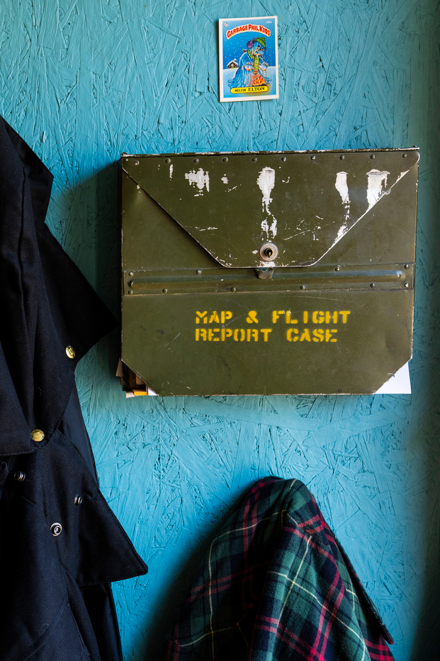 A metal box hung on a wall that says 'Map & Flight Report Case' on it.