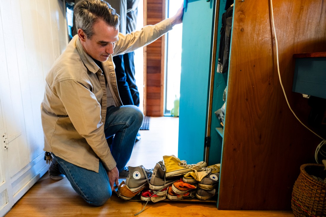 Alex Eaves squatting on the ground in front of a storage cabinet.