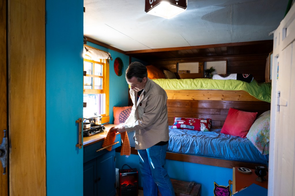 Alex Eaves standing inside of his box truck turned tiny home.