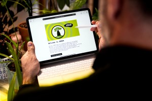 A person holding an iPad with a keyboard attached. It's open to a screen that says 'Welcome to Arbor' on it.