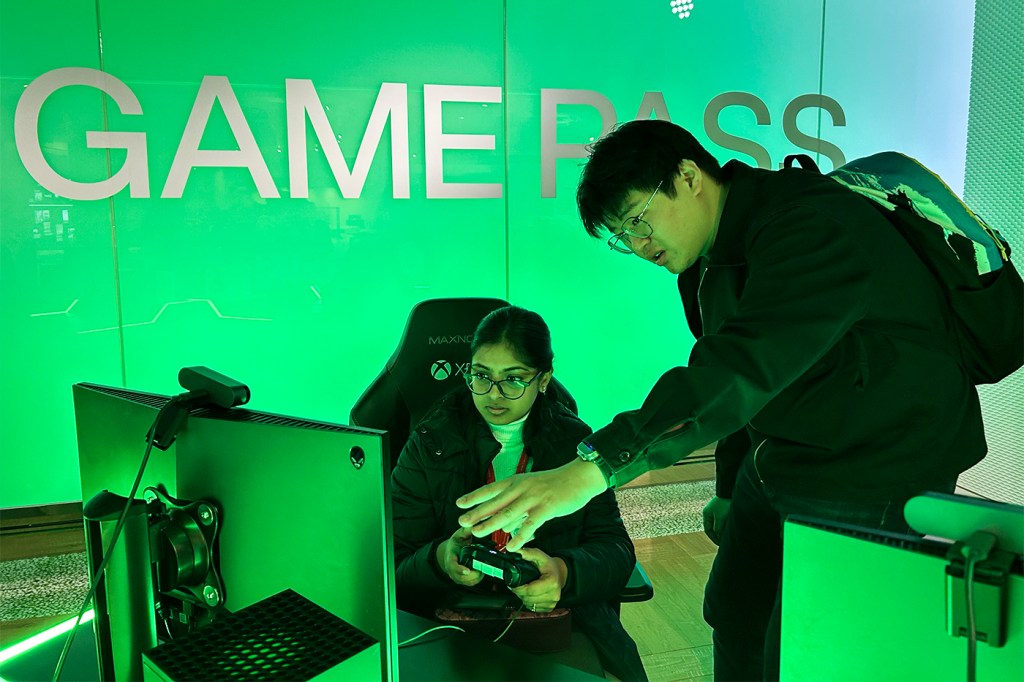 Two people looking at a TV screen in a room that is lit up in green.