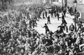 A black and white photo of a crowd of rioters gathering in East London.