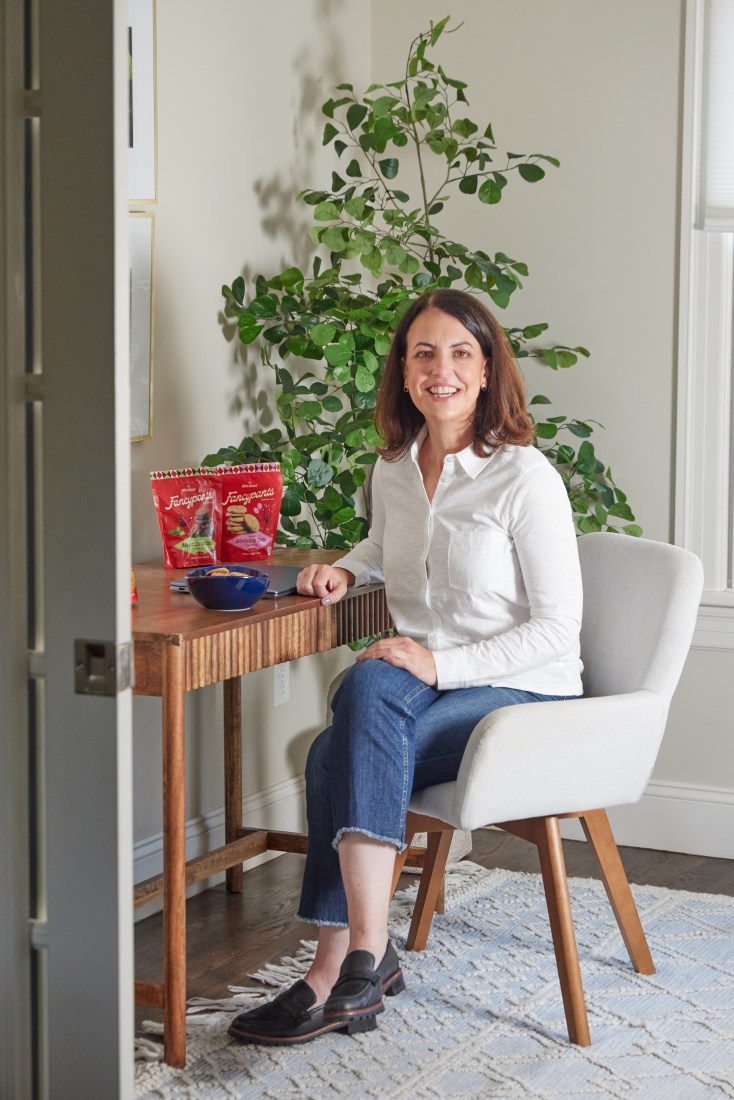 Maura Duggan sitting in a chair at a desk with Fancypants cookies on it.