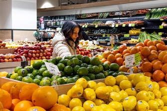 A person browsing for produce in the grocery store.