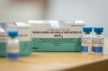 Boxes and vials of the Measles vaccine on a table.