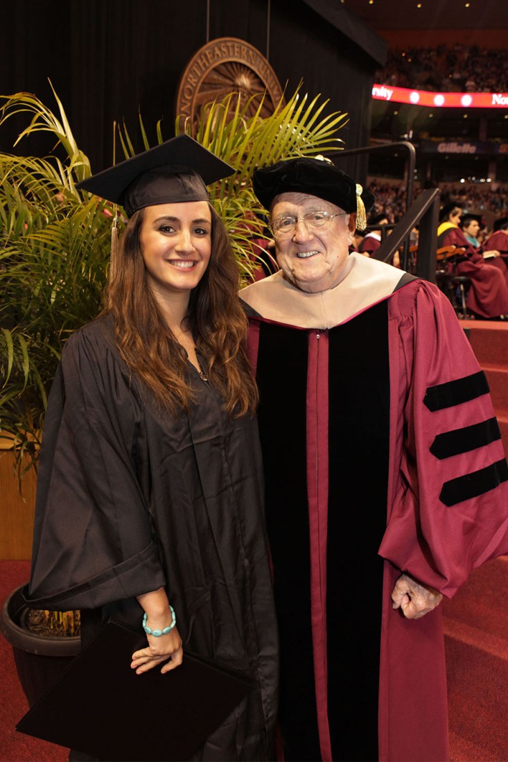 Richard Ockerbloom wearing ceremonial robes standing next to his grandaughter Christine Ockerbloom in her graduation cap and gown.