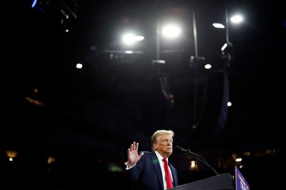 Donald Trump speaking on stage at an event.