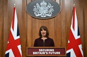 Rachel Reeves standing behind a podium next to two Union Jack Flags.