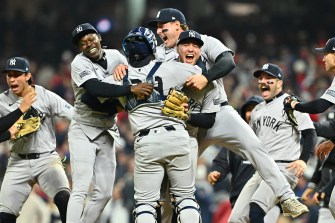 Yankees baseball players jumping on top of each other in celebration.