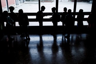 Silhouettes of groups of people in a school.