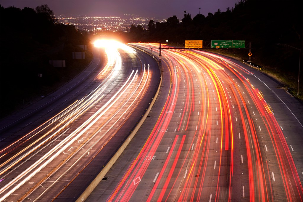 A time lapse photo of cars driving along a highway.