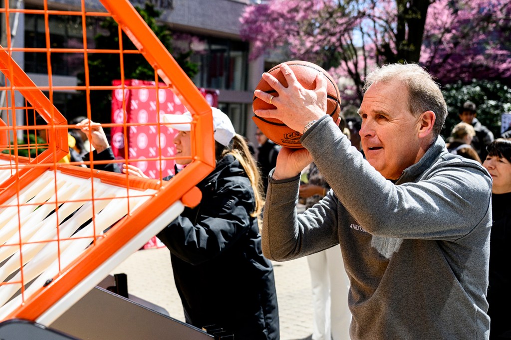 Jim Madigan holding a basketball prepared to shoot on a net.