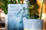 The author&#039;s new book, which has a light blue color, featured between two potted plants.