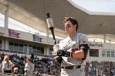 Northeastern player prepares to bat during a baseball beanpot game with fans in the background.