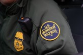 A border patrol agent&#039;s jacket with a &#039;US Border Patrol&#039; patch on the sleeve and a radio on the front.
