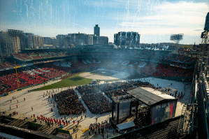 Graduates gather on the field at Fenway Park during Northeastern’s Commencement as fireworks rise overhead.