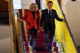 President Emmanuel Macron and his wife Brigitte Macron walking down the steps of a plane.