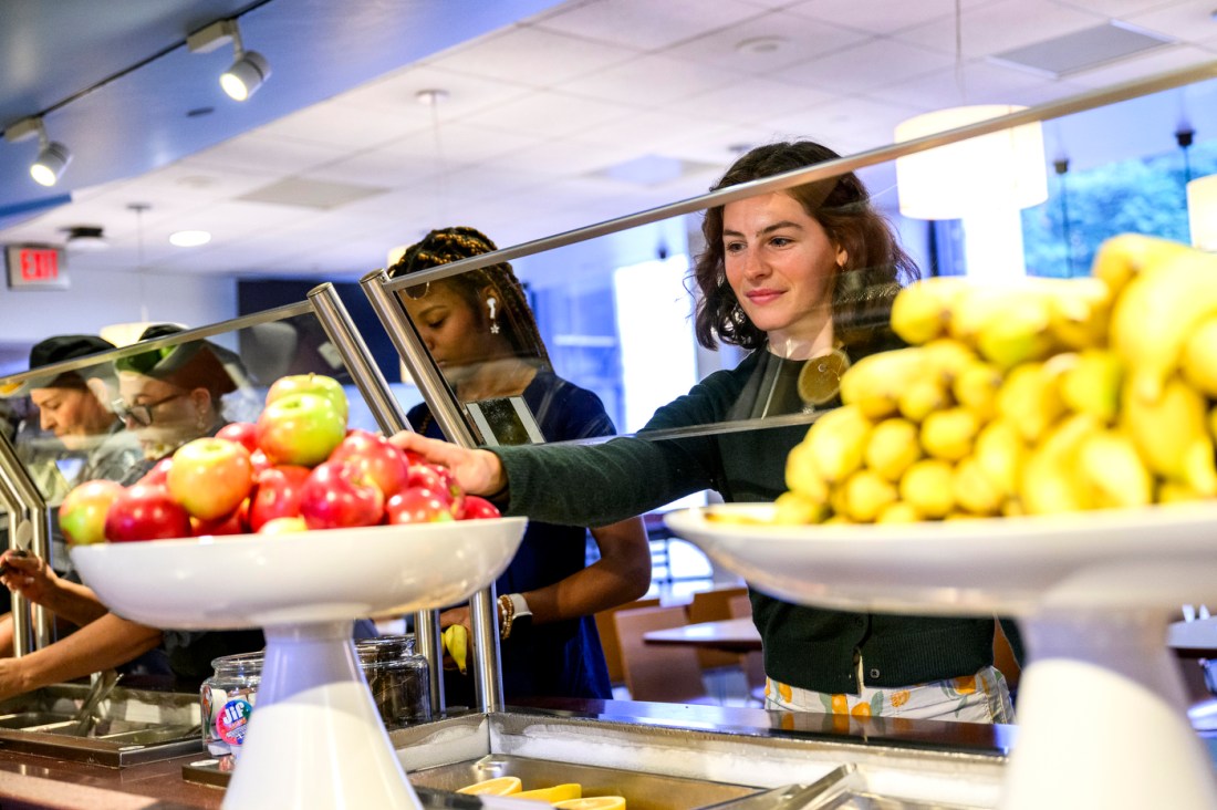 Campus dietitian Johannah Gaitings-Harrod selects fruit from a self-serve station at Northeastern’s Stetson East Dining Hall.